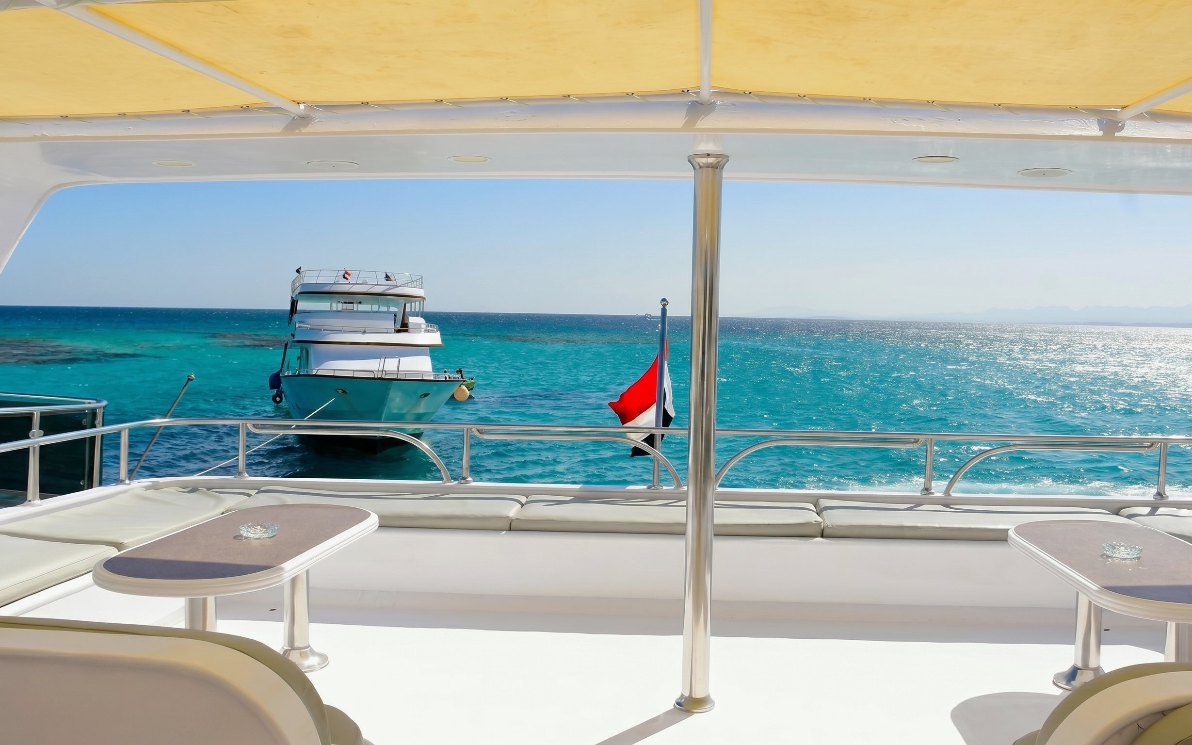 Boat anchored near Orange Bay Island, Hurghada, with clear blue water and deck view.