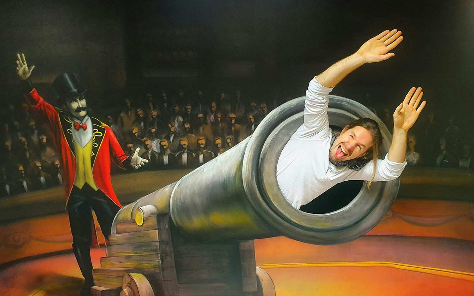 Man posing inside cannon at Museum of Fantastic Illusions.