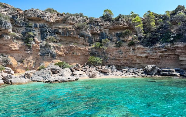 Hidden beach with clear turquoise water and rocky cliffs in Korčula, Dubrovnik.