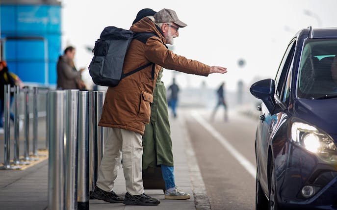Traveler hailing a private car at LaGuardia Airport for transfer service.