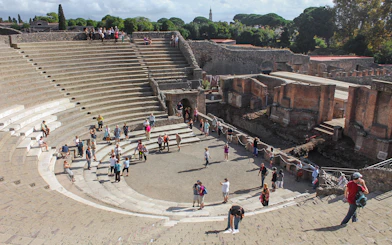Tour group with guide at Pompeii amphitheatre, Italy.