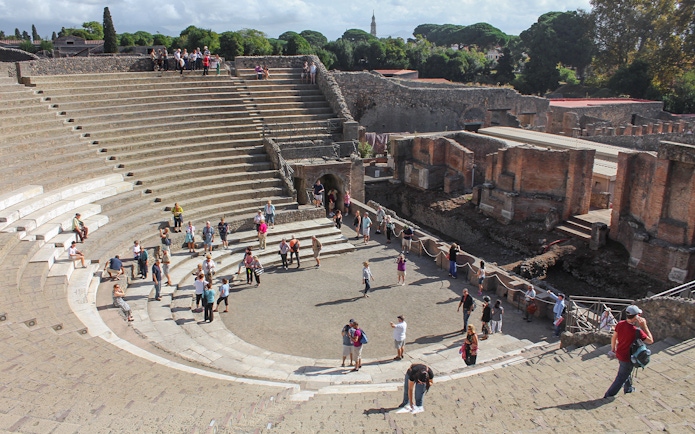 Tour group with guide at Pompeii amphitheatre, Italy.