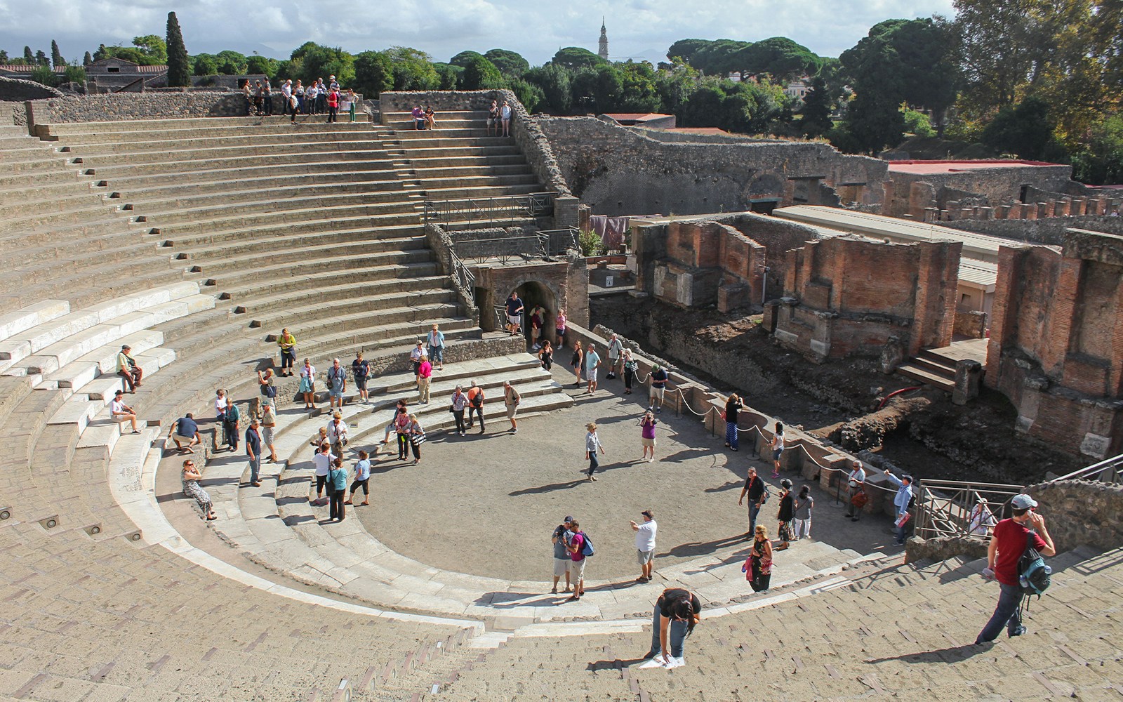 Tour group with guide at Pompeii amphitheatre, Italy.