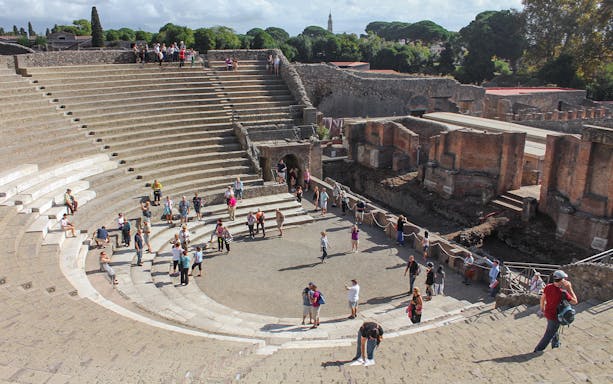 Tour group with guide at Pompeii amphitheatre, Italy.