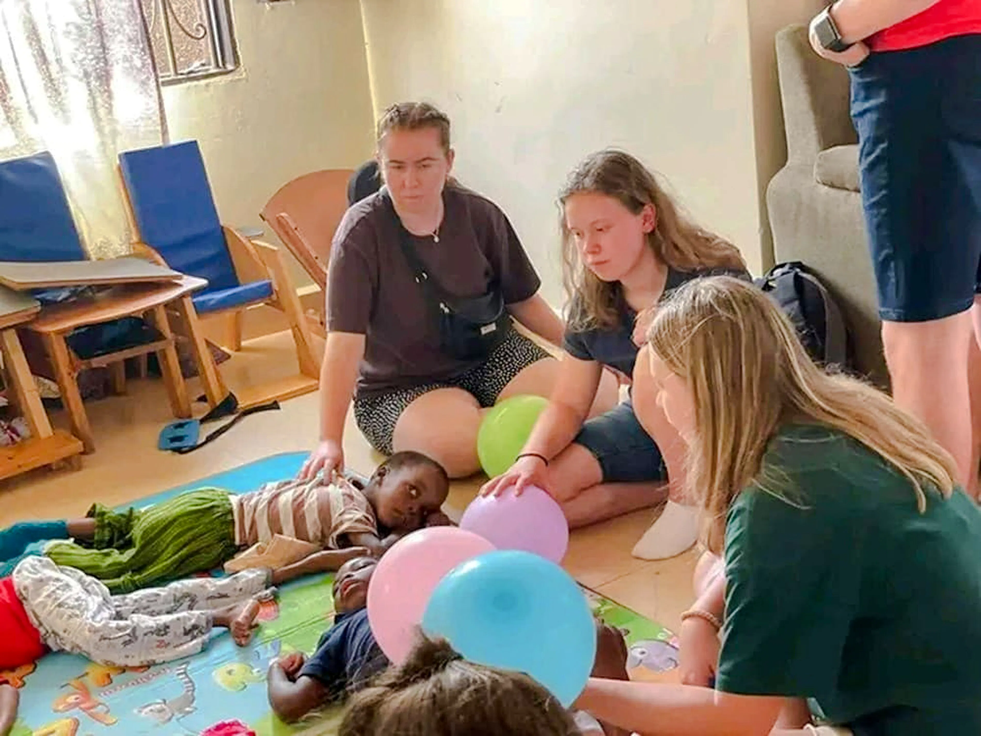 Visitors interacting with children at a Nairobi children's home during the Kibera Slum walking tour.