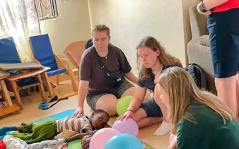 Visitors interacting with children at a Nairobi children's home during the Kibera Slum walking tour.