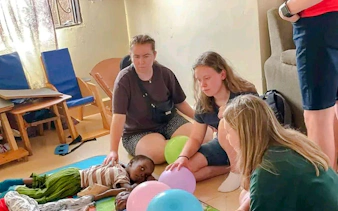 Visitors interacting with children at a Nairobi children's home during the Kibera Slum walking tour.