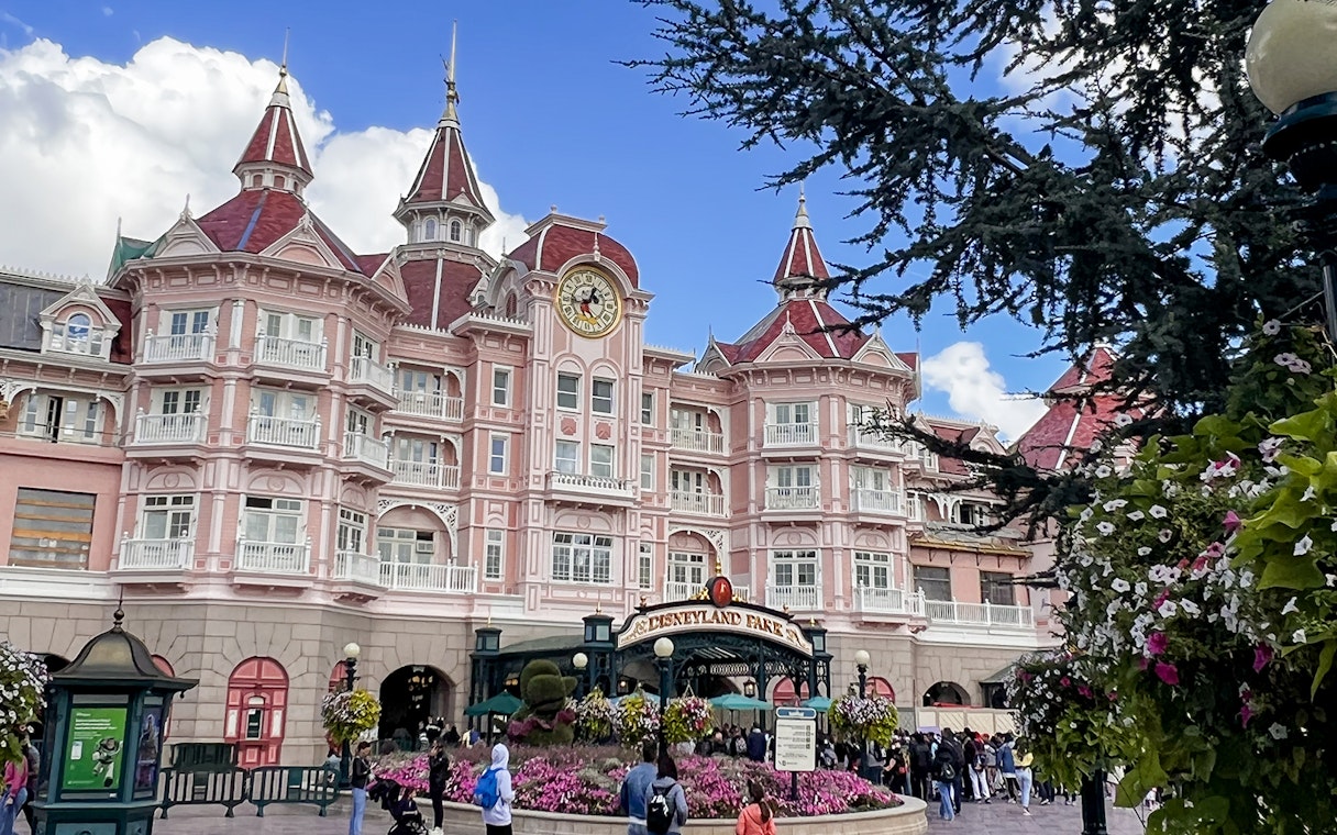 Disneyland Paris entrance with pink Victorian-style hotel and clock tower.