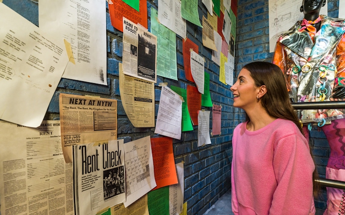 Visitor observing Broadway show posters and memorabilia at The Museum Of Broadway.
