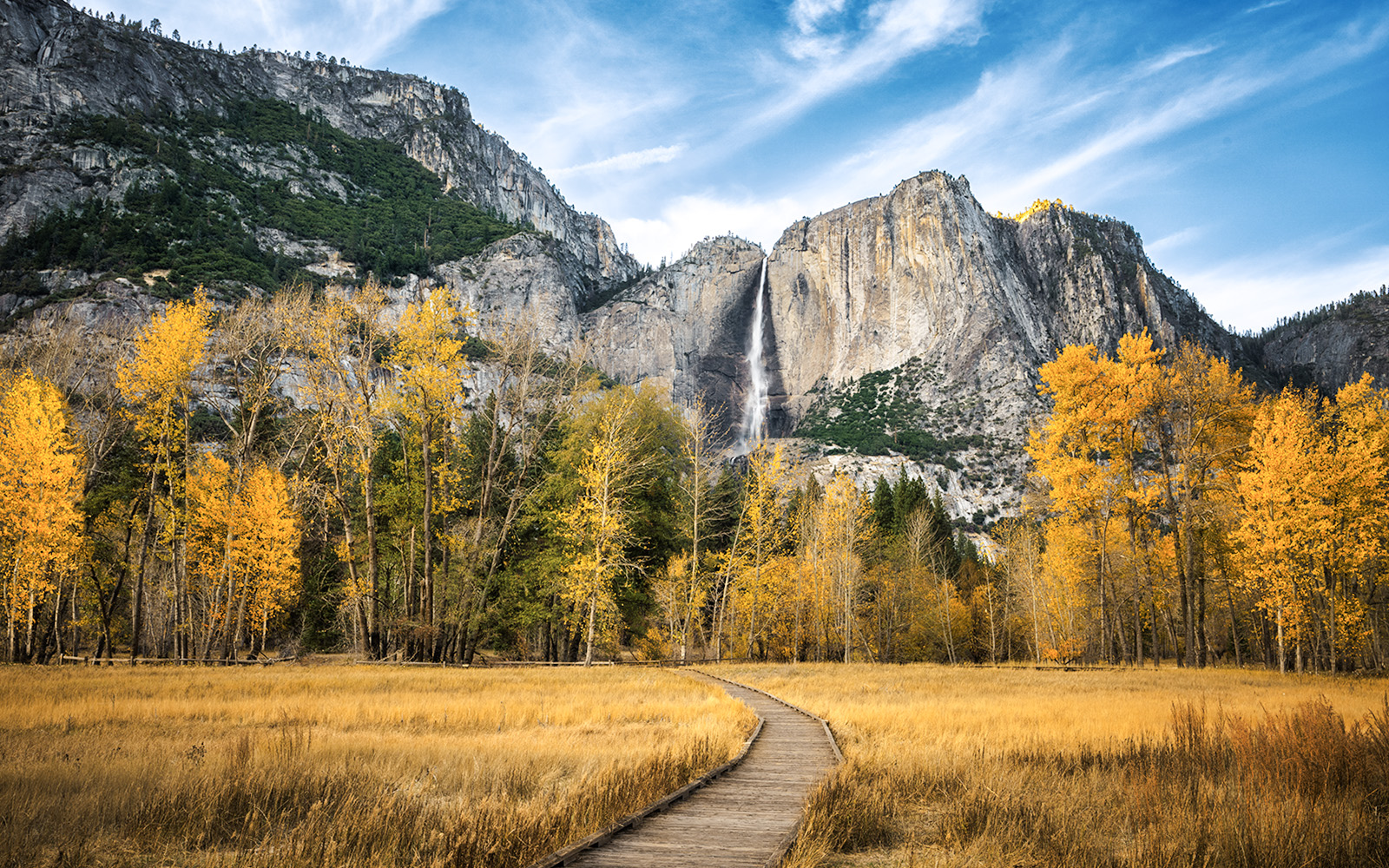 Pathway leading to Yosemite Falls with autumn trees in Yosemite National Park.
