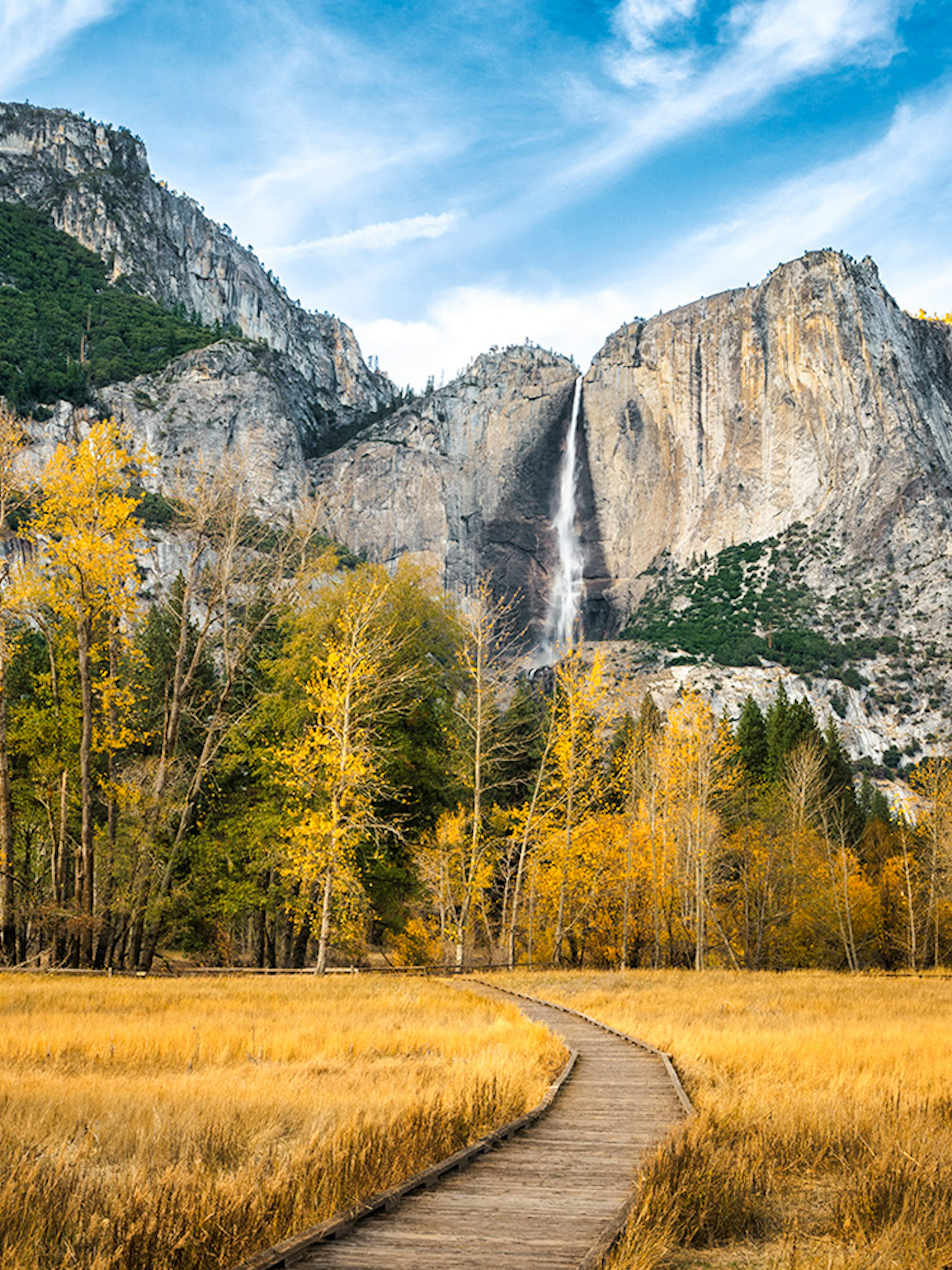 Pathway leading to Yosemite Falls with autumn trees in Yosemite National Park.