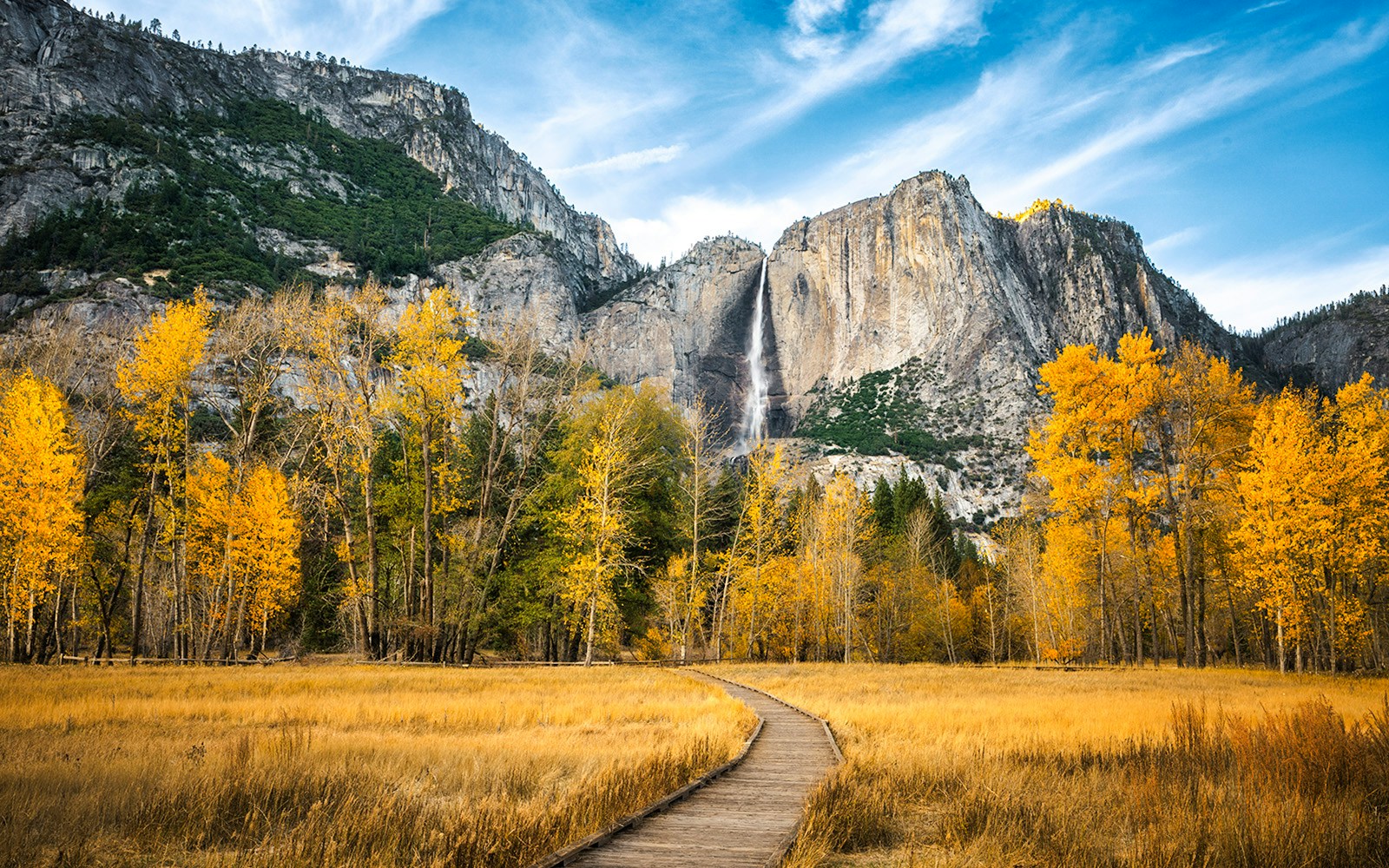 Pathway leading to Yosemite Falls with autumn trees in Yosemite National Park.