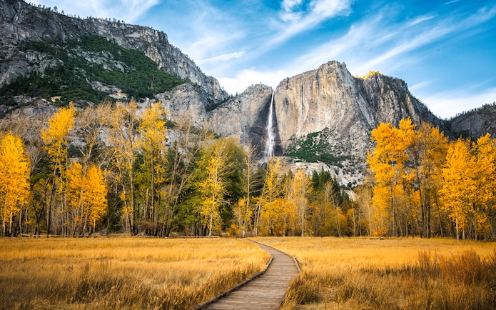 Pathway leading to Yosemite Falls with autumn trees in Yosemite National Park.