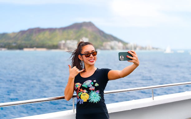 Guest taking a selfie with Diamond Head in the background on a cruise in Oahu.