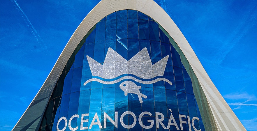 Oceanografic Valencia entrance with logo under blue sky.