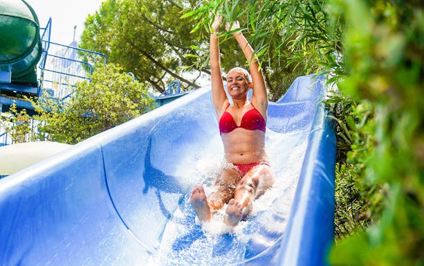 Person enjoying a water slide at Illa Fantasia, part of the Combo: Illa Fantasia + Barcelona Aquarium tour.