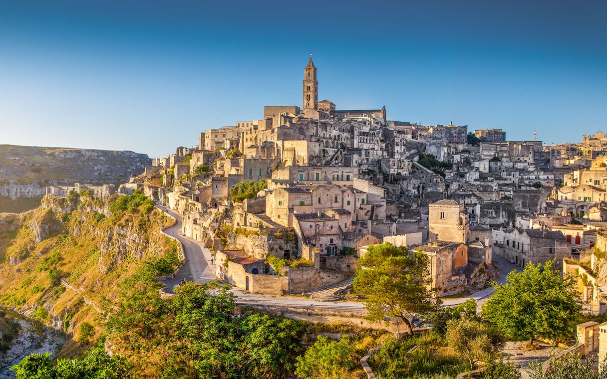 Sassi of Matera ancient stone buildings and winding paths under clear sky.