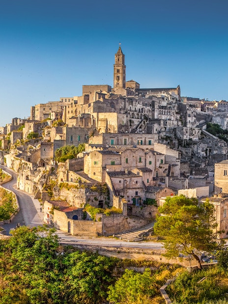 Sassi of Matera ancient stone buildings and winding paths under clear sky.