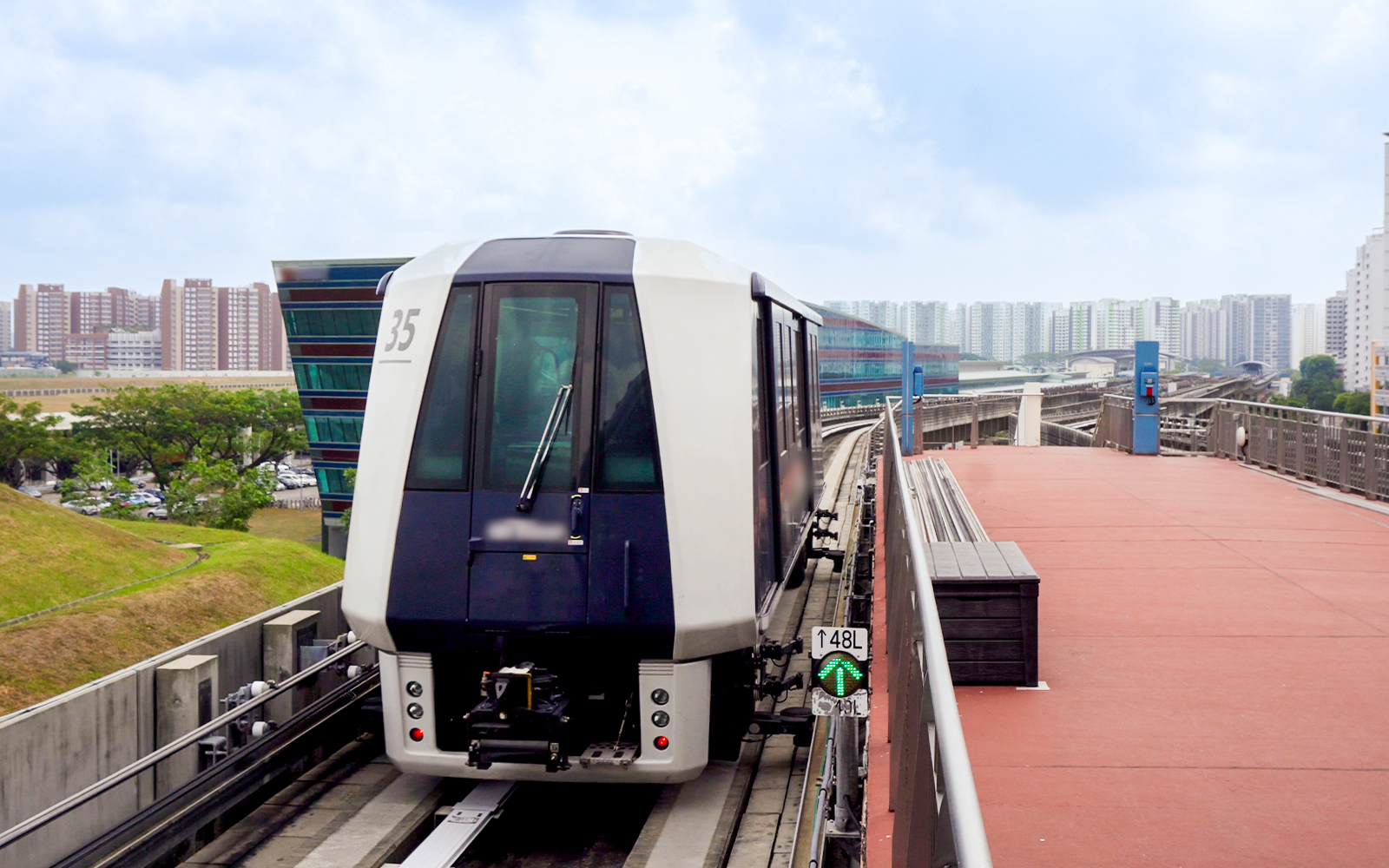 Singapore MRT train on elevated track with city skyline in the background.
