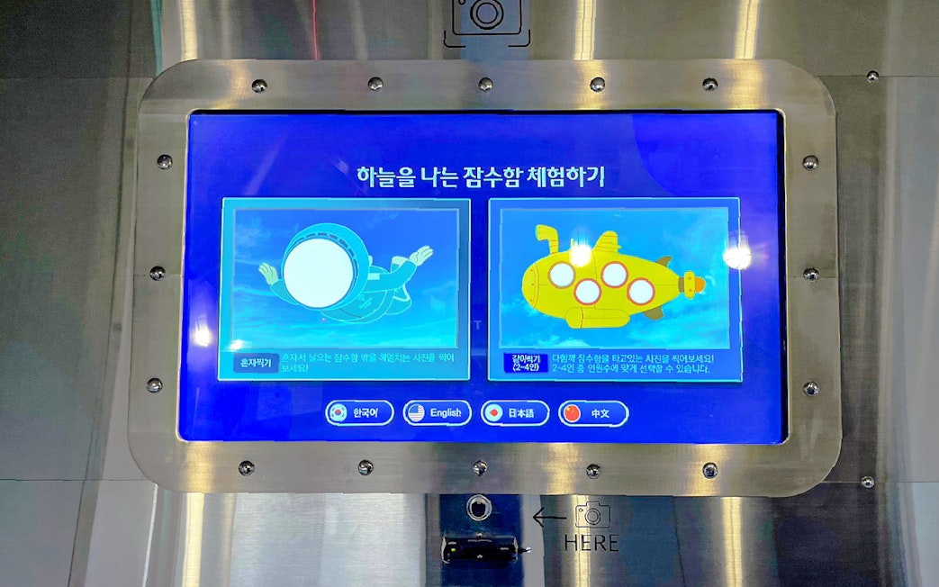 Interactive display at Busan Tower entrance showing submarine experience options.