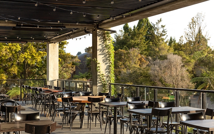 Outdoor dining area at Te Puia with forest view, part of the Te Rā Guided Experience.