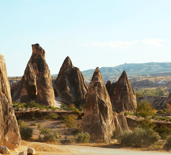 Tourists riding ATVs among rock formations in Cappadocia, Turkey.