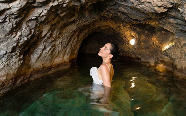 Woman relaxing in a thermal cave pool at QC Terme Bagni Vecchi di Bormio.
