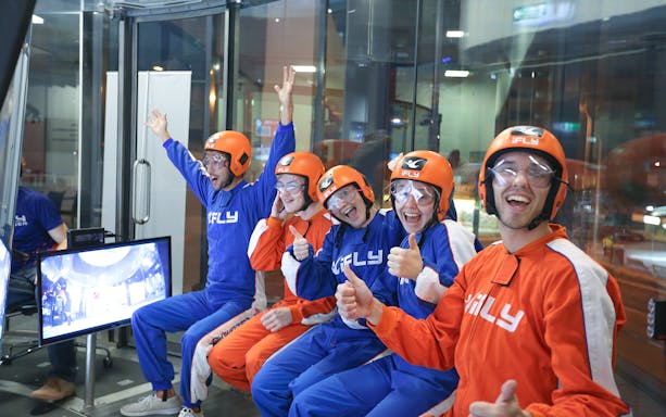 Group of people in flight suits and helmets at iFly Sydney Indoor Skydiving.