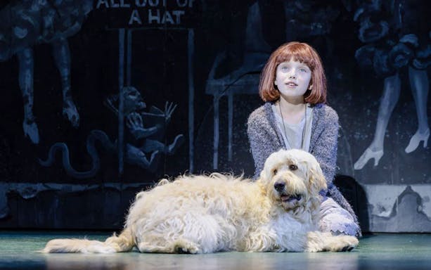 Young girl with a dog on stage during an Annie performance.