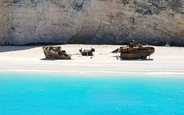 Shipwreck on Navagio Beach, Zakynthos, Greece, with turquoise water and cliffs in the background.