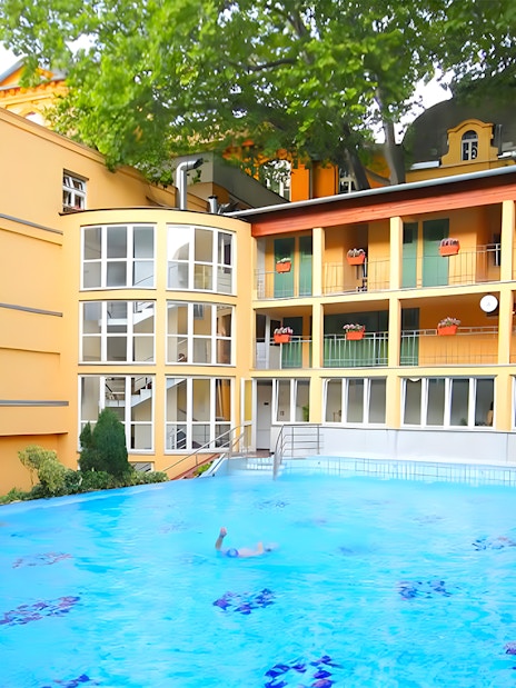 Lukacs Baths outdoor pool with swimmers in Budapest.