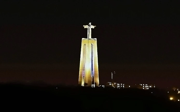 Sanctuary of Christ the King illuminated at night, Lisbon, Portugal.