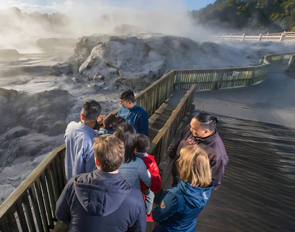 Visitors observing geothermal activity at Te Puia, Rotorua during guided tour from Auckland.