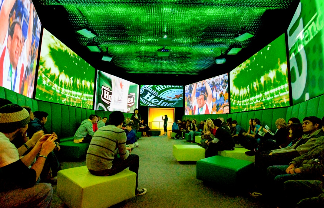 Guests at Heineken Experience Amsterdam exploring interactive exhibits and tasting area.