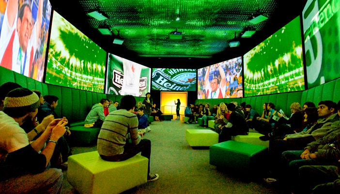 Guests at Heineken Experience Amsterdam exploring interactive exhibits and tasting area.