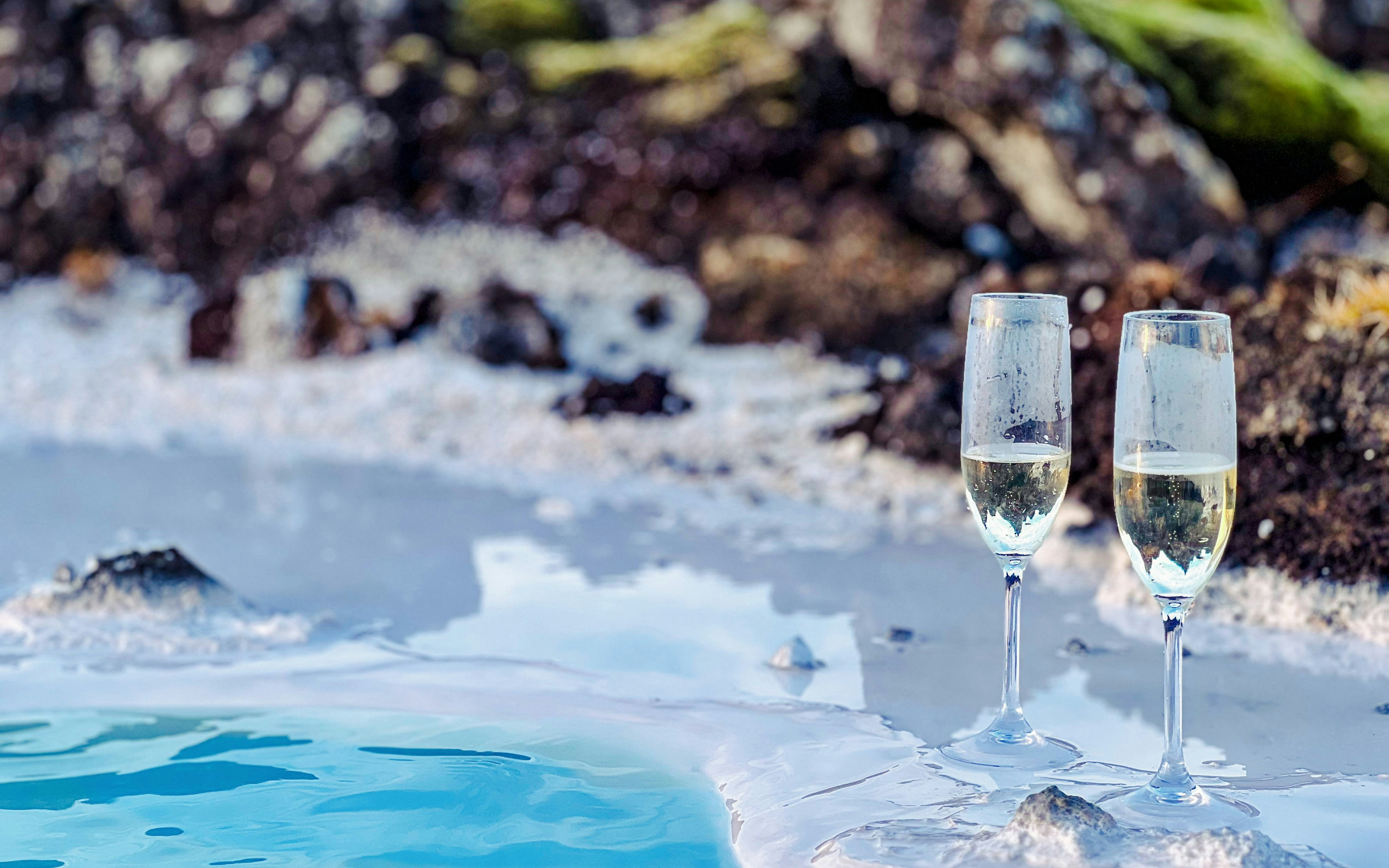Champagne glasses by the Blue Lagoon's geothermal waters in Iceland.