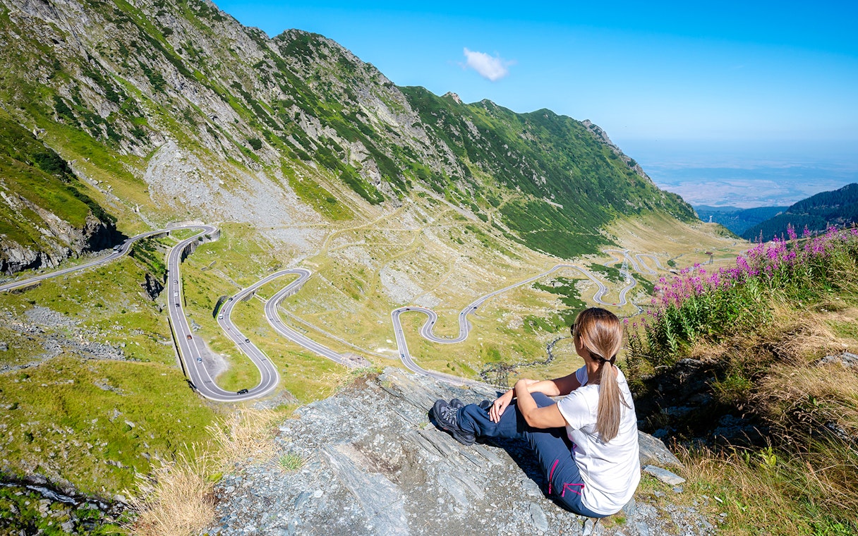 Woman overlooking the winding Transfagarasan Highway in Romania.
