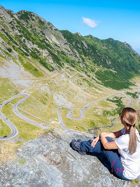 Woman overlooking the winding Transfagarasan Highway in Romania.