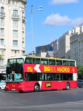 Big Bus Madrid tour bus in city center with historic buildings in background.