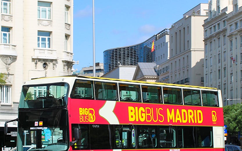 Big Bus Madrid tour bus in city center with historic buildings in background.