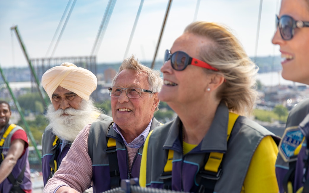 Visitors enjoying a climb at the O2 in London during daytime.