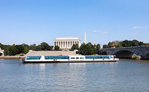 Cruise boat on the Potomac River with Lincoln Memorial and Washington Monument in the background.
