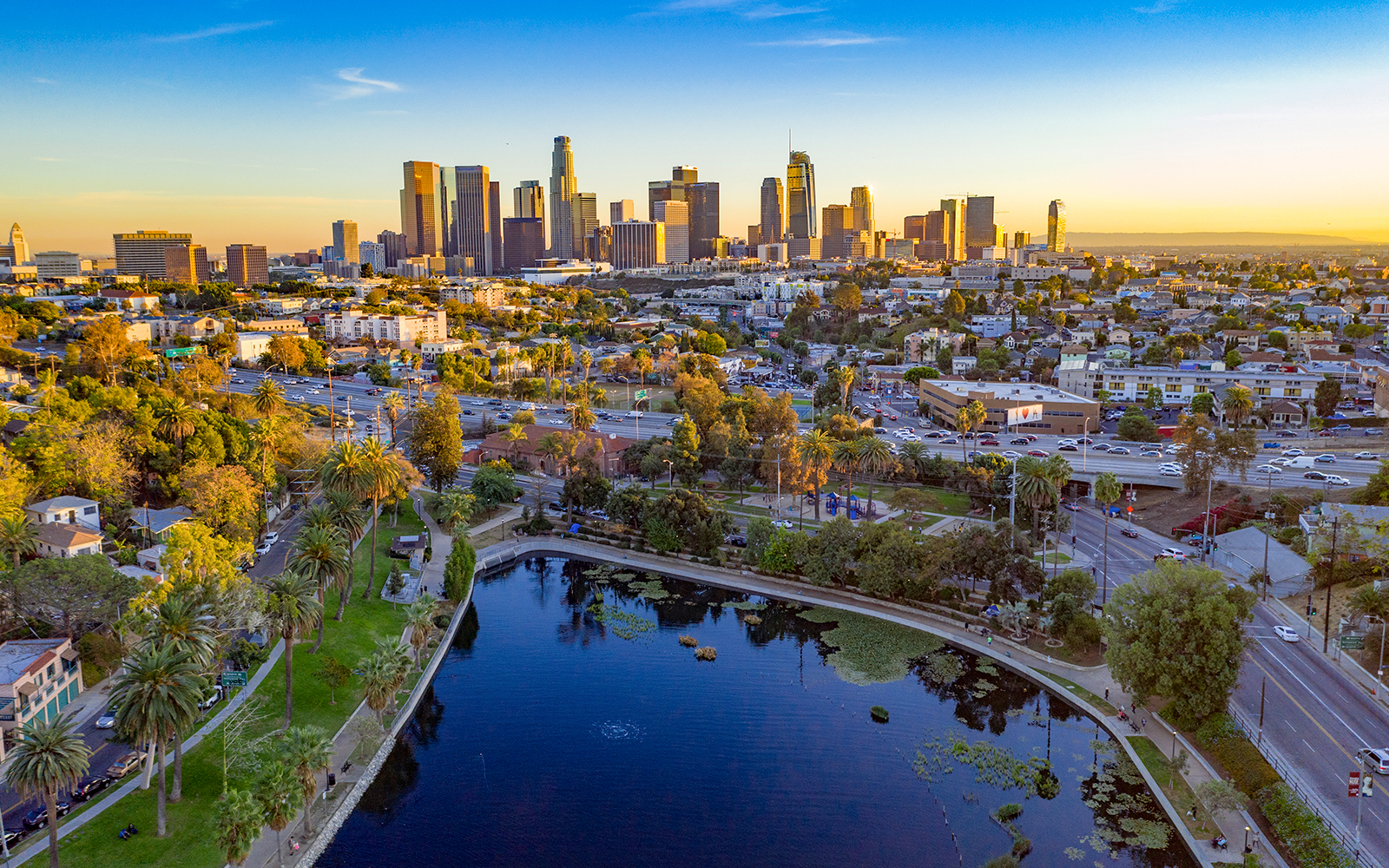 Downtown Los Angeles skyline with high-rise buildings and urban landscape at sunset.