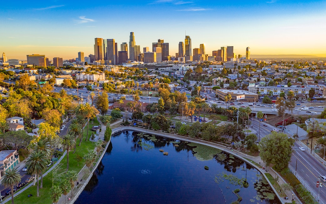 Downtown Los Angeles skyline with high-rise buildings and urban landscape at sunset.