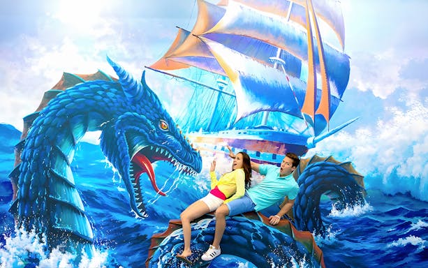 Couple posing with sea dragon mural at Aquaria Phuket.