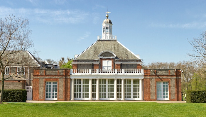 Serpentine Gallery facade in Kensington Gardens, London, with clear blue sky.
