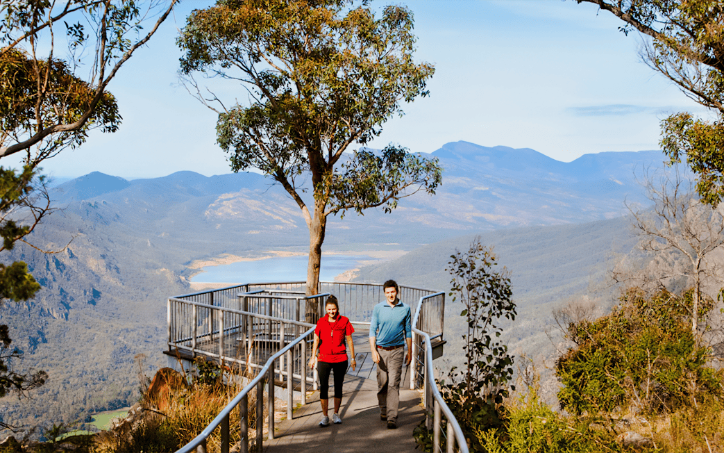 Couple walking on path at Boroka Lookout, Grampians National Park, with mountain view.