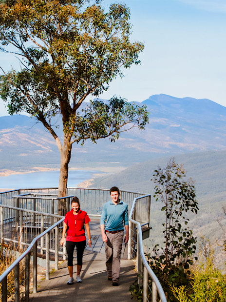 Couple walking on path at Boroka Lookout, Grampians National Park, with mountain view.