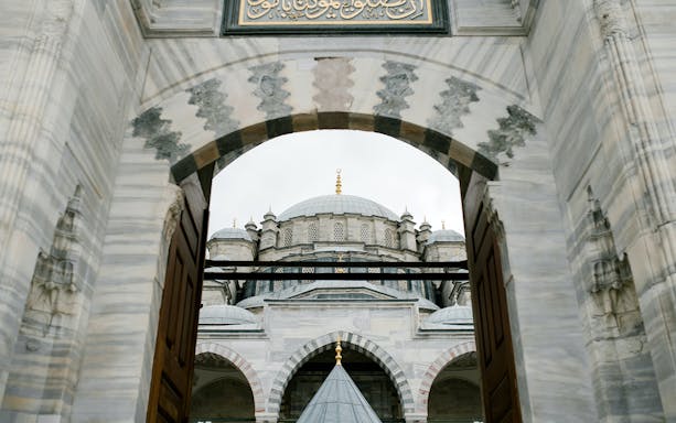 Suleymaniye Mosque entrance view, Istanbul, with domes and arches visible.