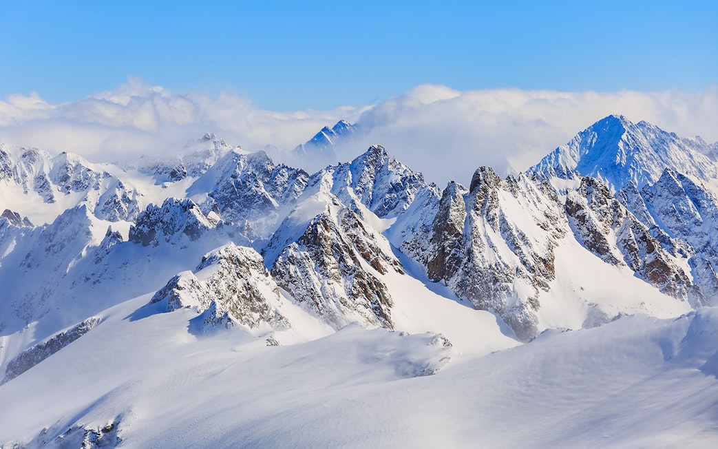Snow-covered peaks of the Swiss Alps viewed from Mt. Titlis in winter.